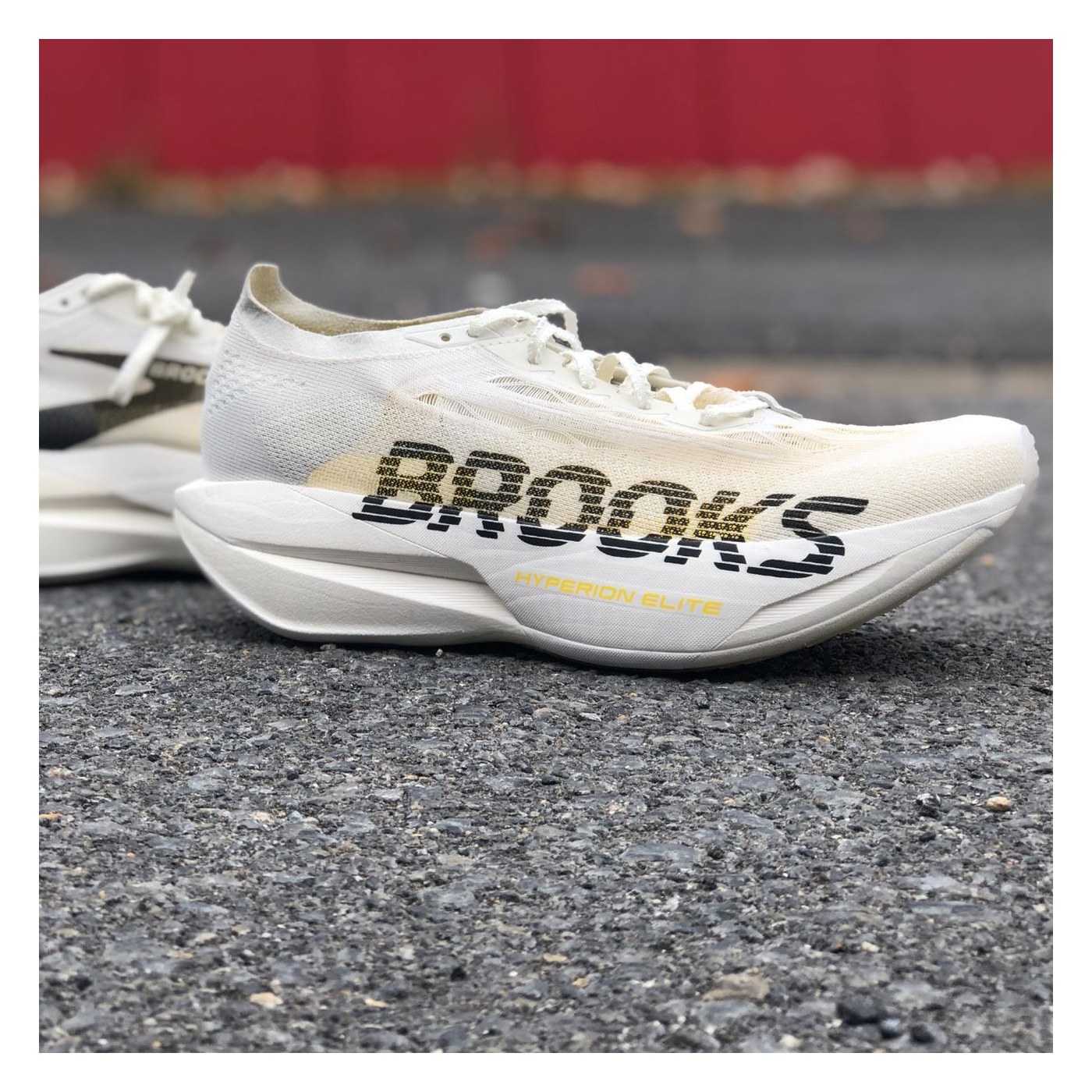Brooks Hyperion Elite 6 posée sur bitume, profil latéral, coloris blanc et or