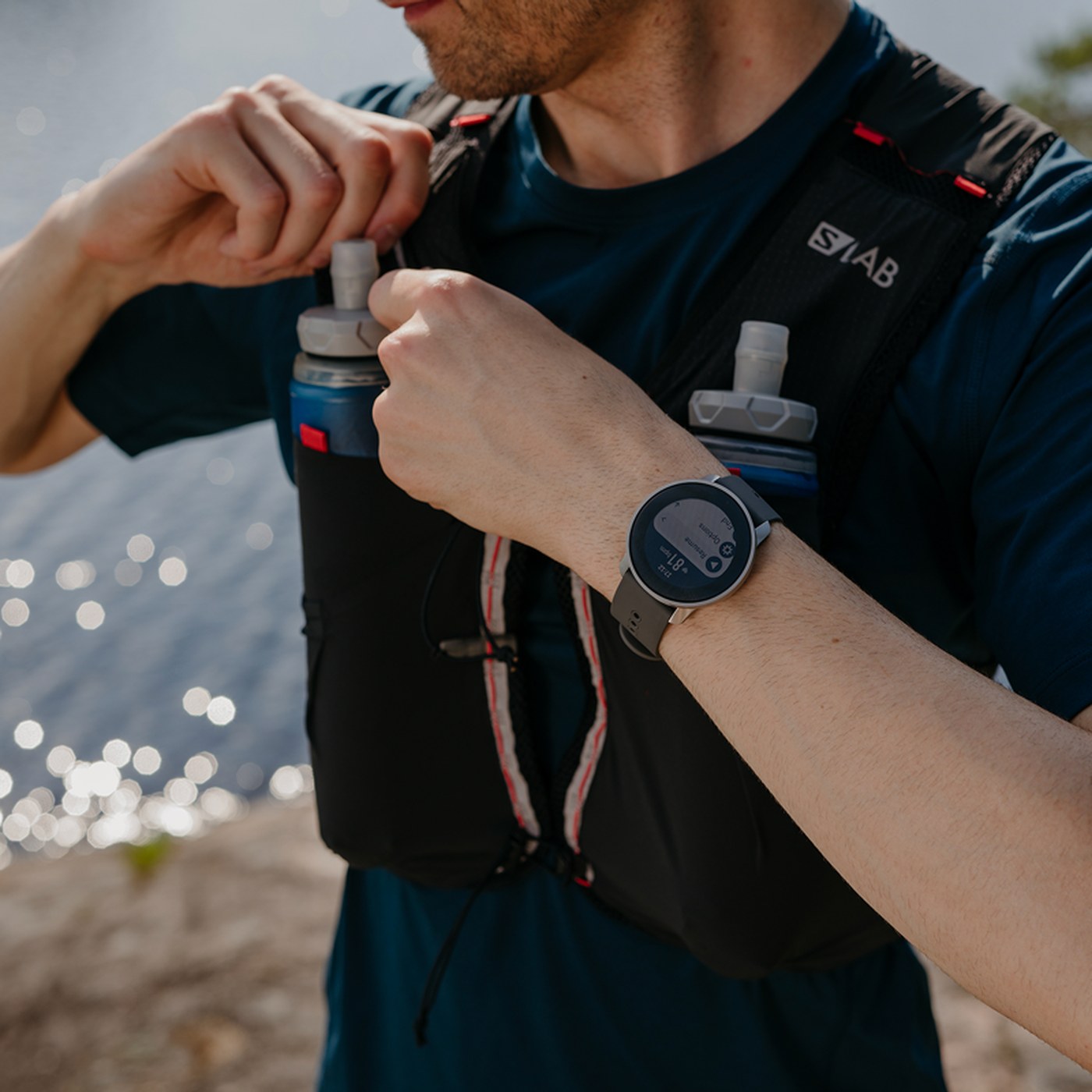 Suunto 9 Peak Pro portée au poignet lors d'une sortie trail avec gilet d'hydratation