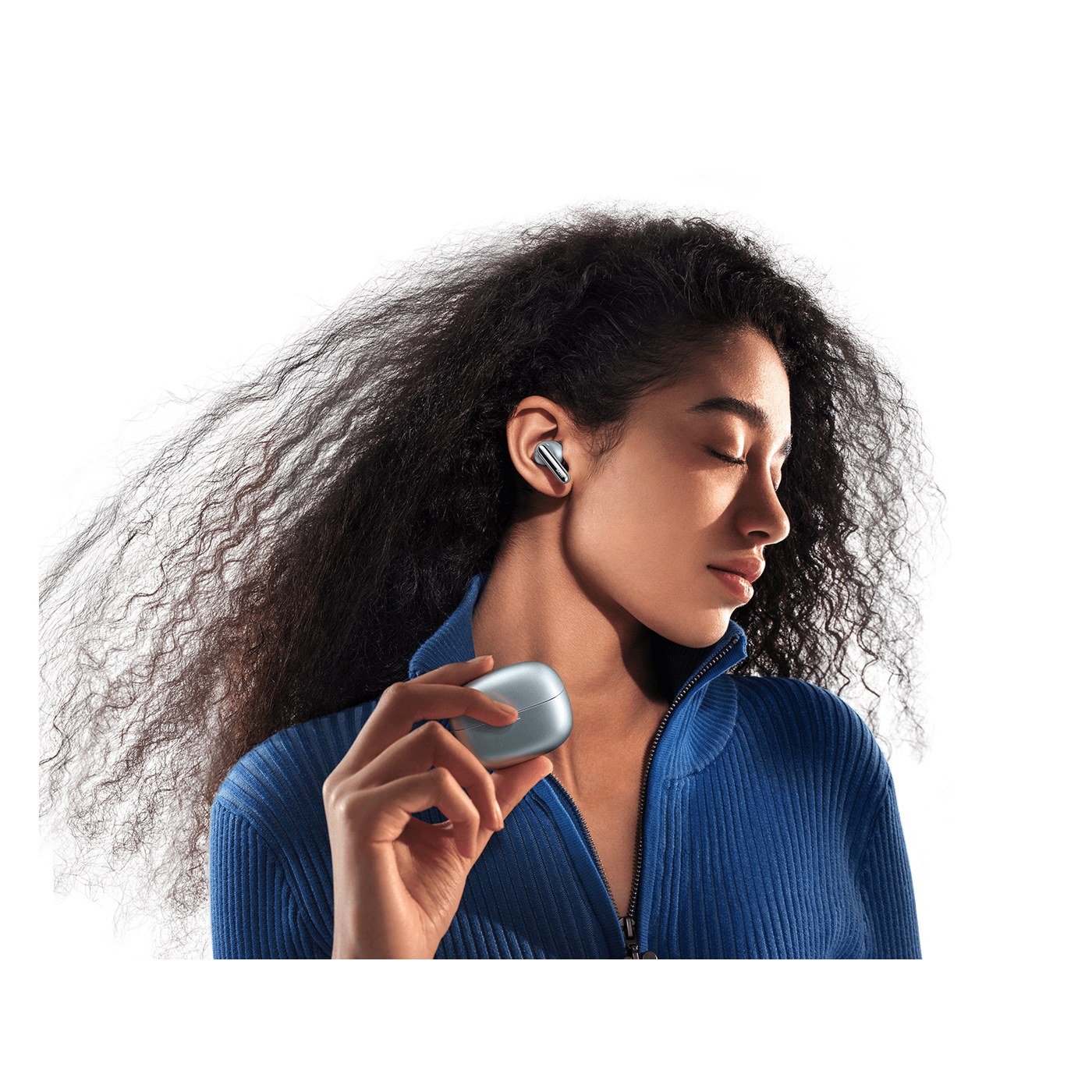 Xiaomi Redmi Buds 8 Pro porté à l'oreille avec son boîtier de charge en main